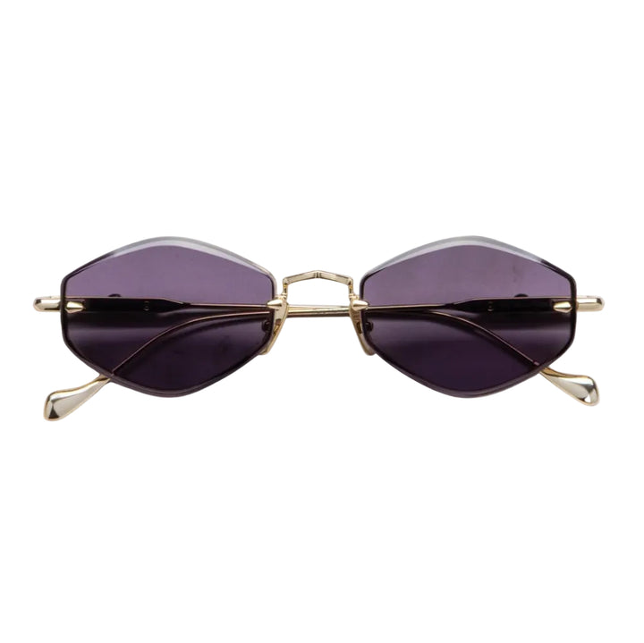 Oversized cat-eye sunglasses with dark purple tinted lenses and a gold metal frame, shown against a plain white background.