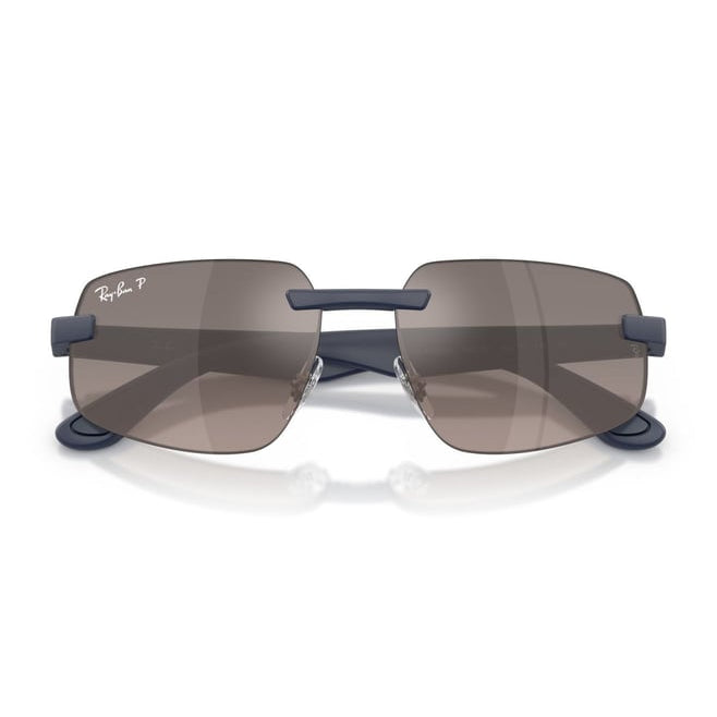Ray-Ban rimless sunglasses with dark gray lenses and navy blue temples, displayed on a clean white background with a subtle reflection.