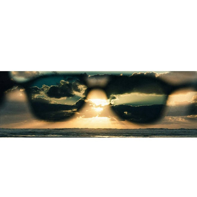 Sunglasses with a sunset over water through the lenses