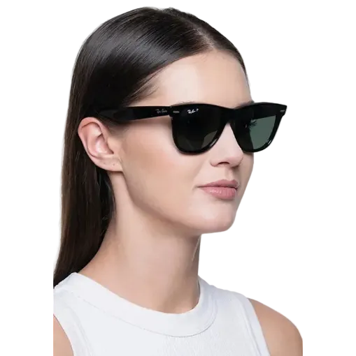 A woman in profile wearing black Ray-Ban sunglasses with dark lenses and a white ribbed tank top, photographed against a light gray studio background.